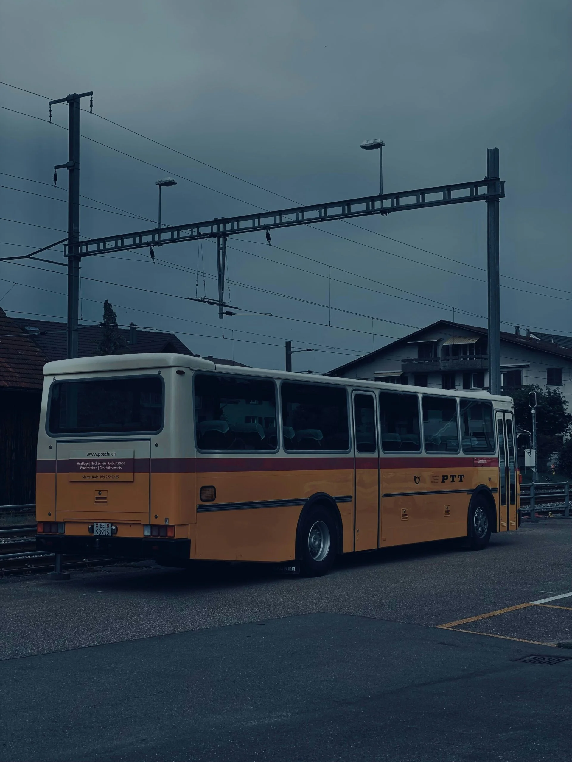 A yellow and white bus parked in a parking lot